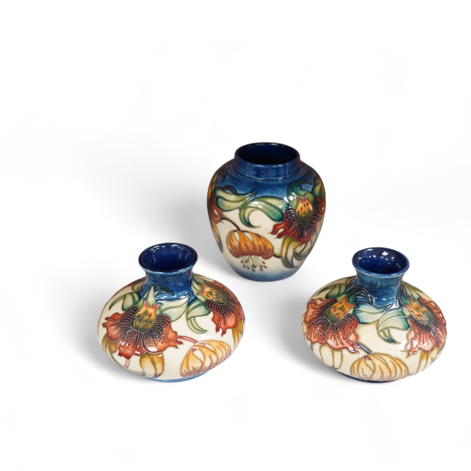 Two modern Moorcroft vases and a jar in the Anna Lily pattern, largest 14cm high